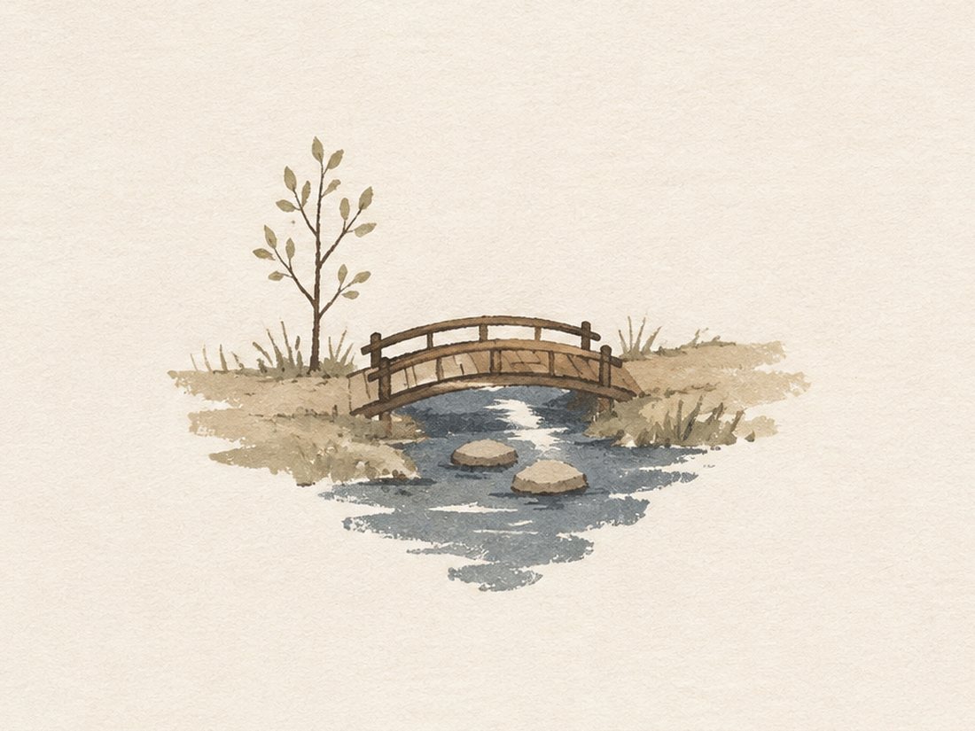 A hand-painted wooden footbridge crossing a quiet stream